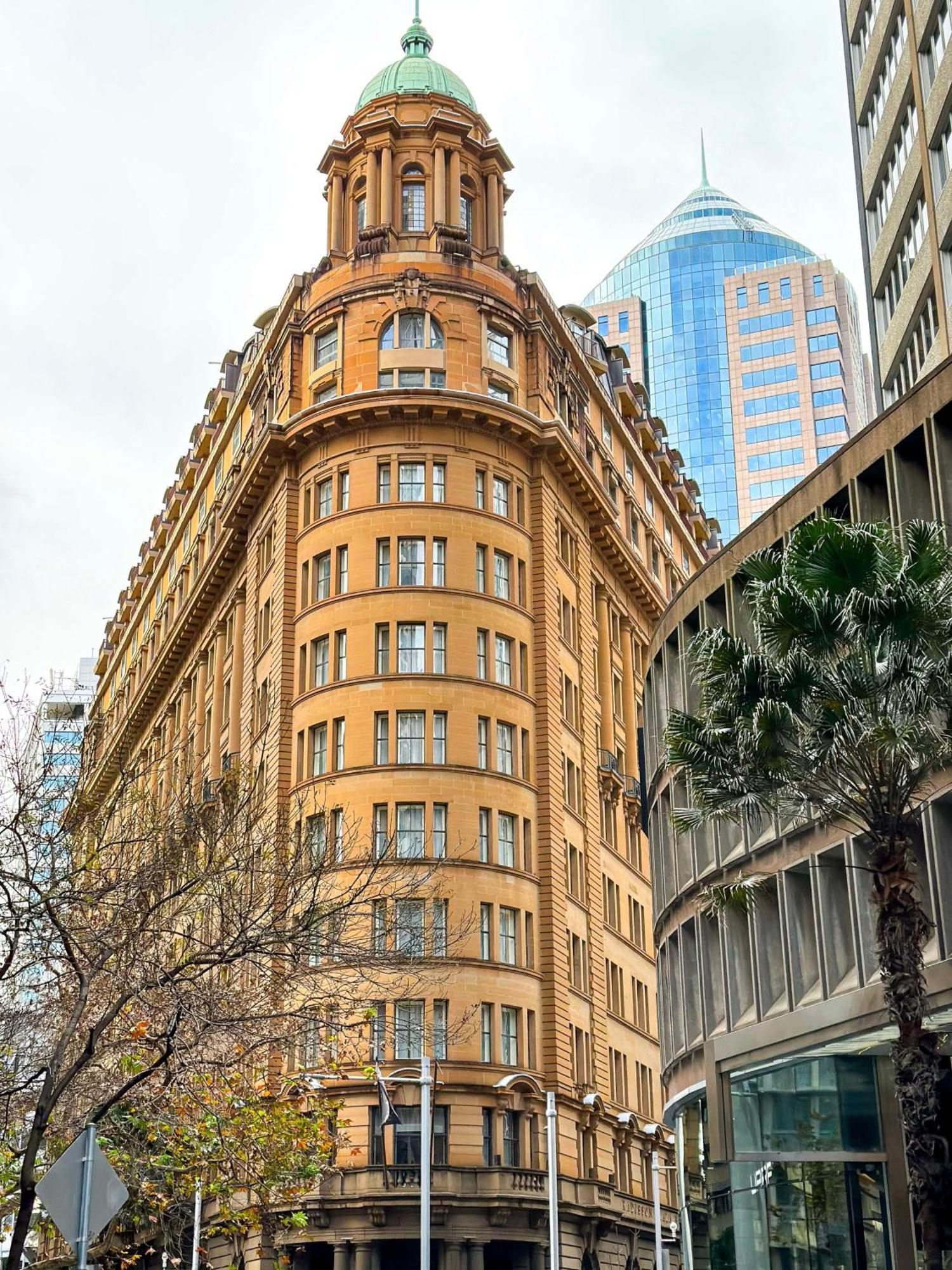 Radisson Blu Plaza Hotel Sydney Eksteriør billede The photo shows a distinctive architectural building with a rounded facade, featuring a tan-colored exterior and multiple windows. This building is likely situated in an urban environment, surrounded by modern skyscrapers, indicated by the glass and 
